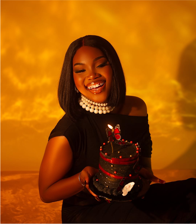 Smiling woman holding cake in golden light