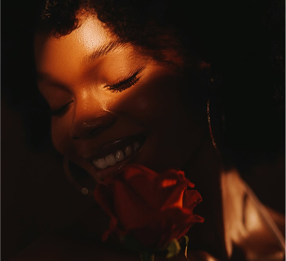 Woman holding rose with closed eyes